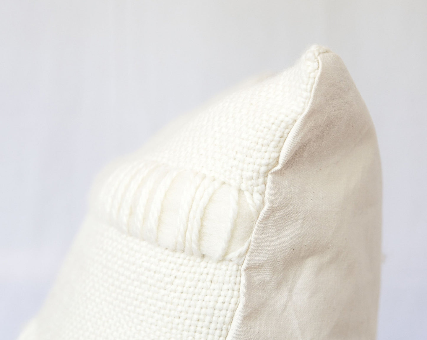 Both sides of handweaving cushion case in merino wool in front and organic cotton at the back