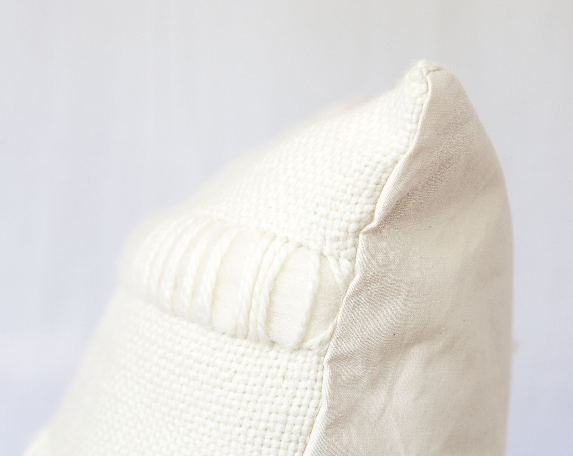 Both sides of handweaving cushion case in merino wool in front and organic cotton at the back