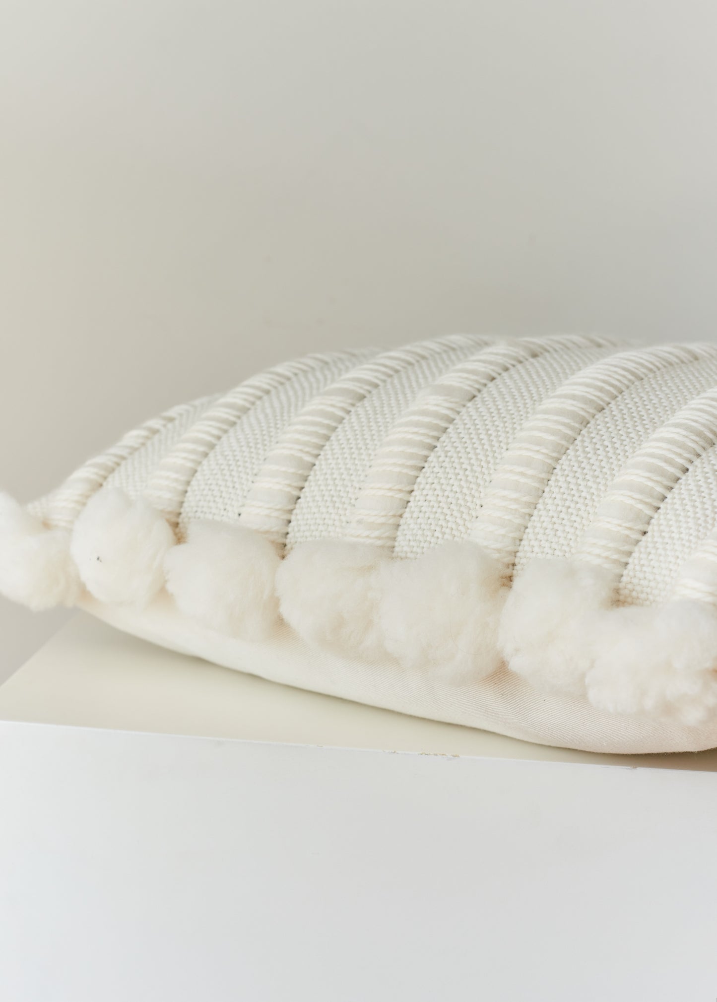 Pom poms side of cushion cover handwoven in chunky merino wool
