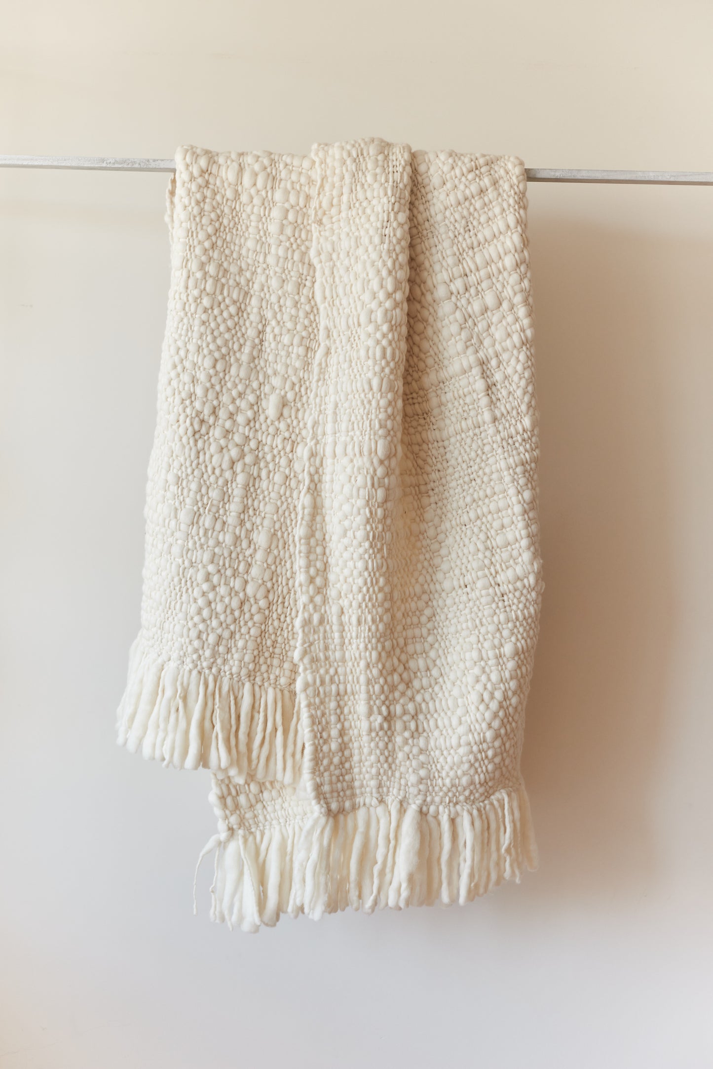 Nube blanket in natural ecru tone, showing handwoven weave and soft texture.