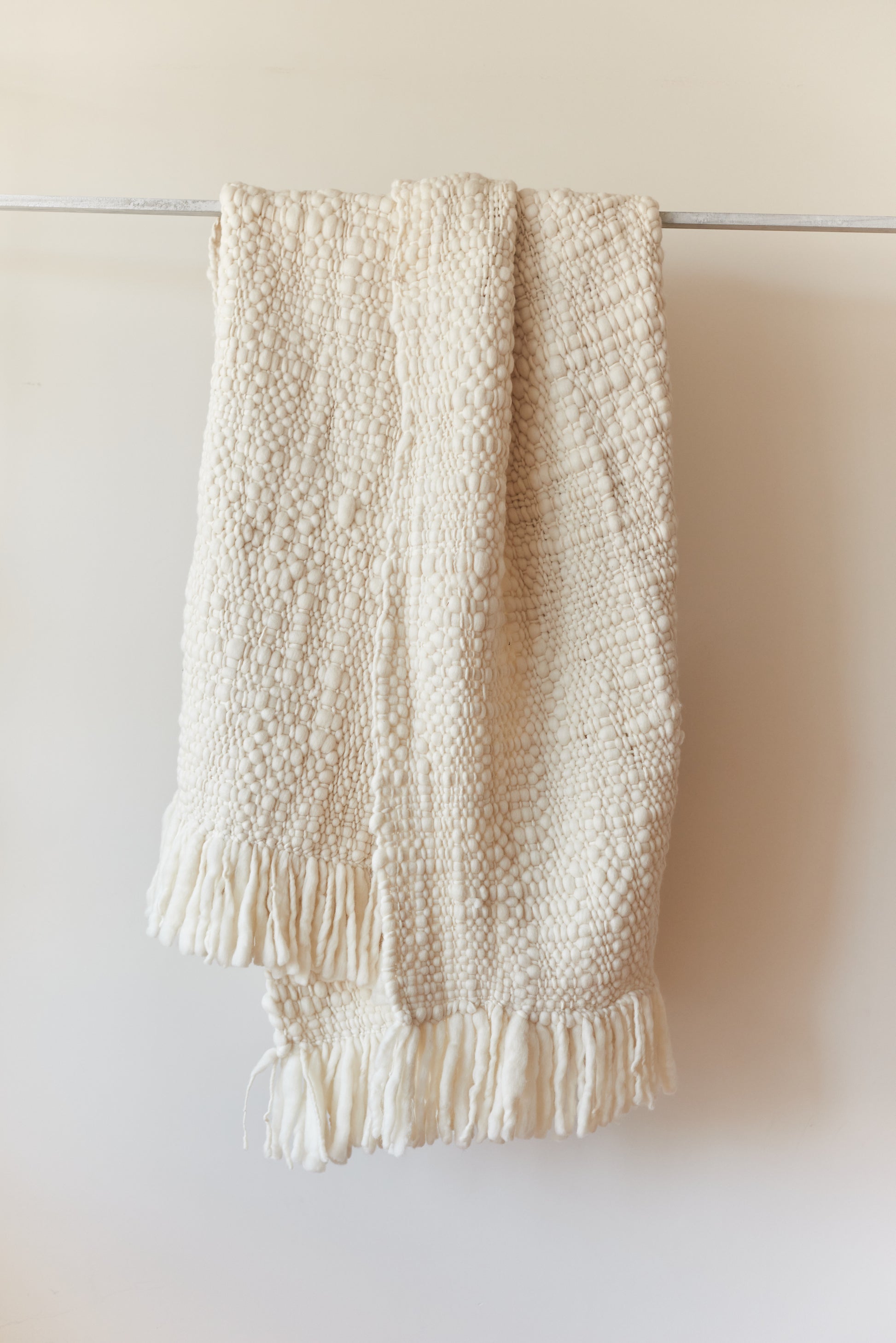 Nube blanket in natural ecru tone, showing handwoven weave and soft texture.