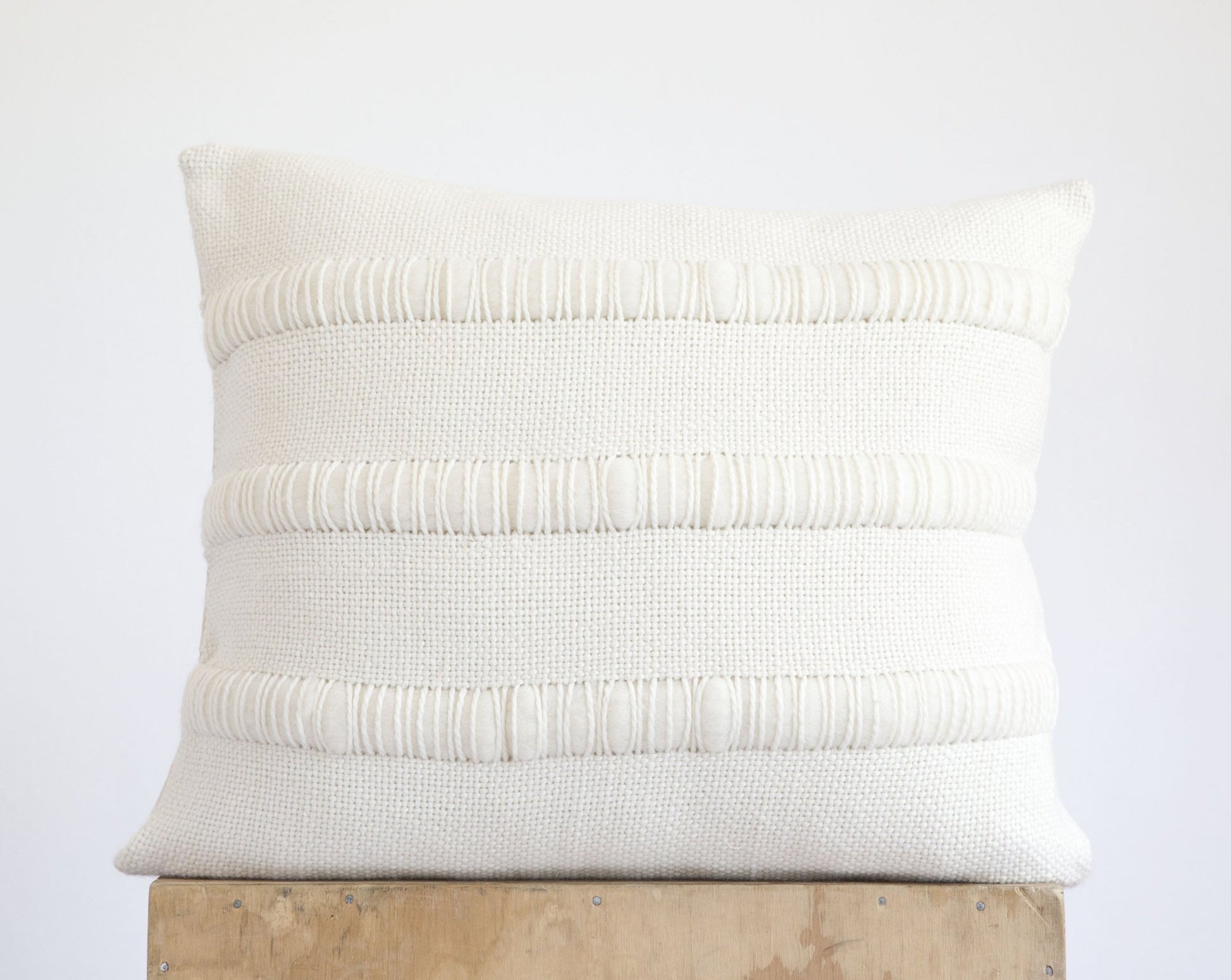 Cream pillow cover with textured stripes of chunky roving merino wool handwoven