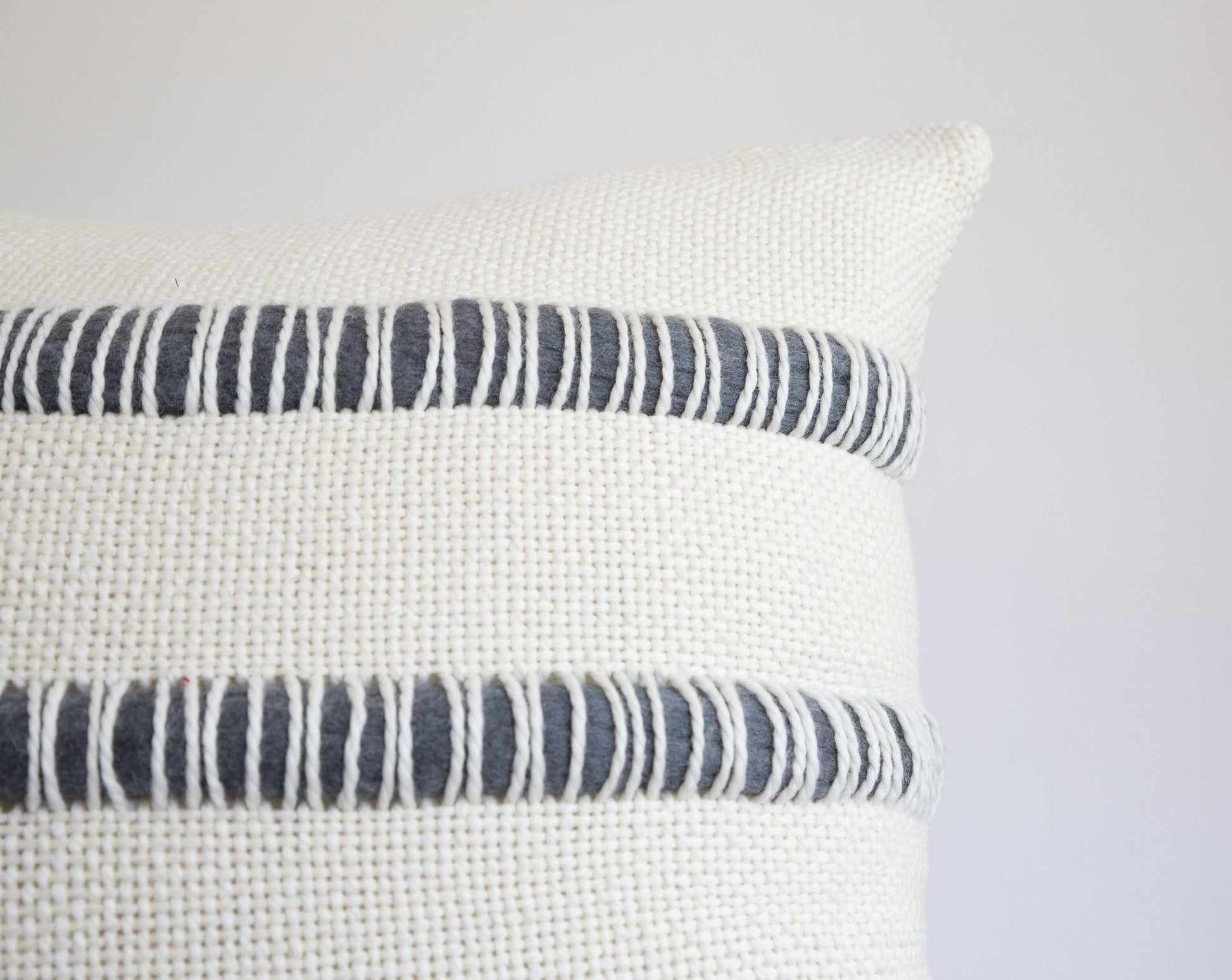 Pillow case handwoven in merino wool with roving stripes of merino wool in stone grey - Close shot corner