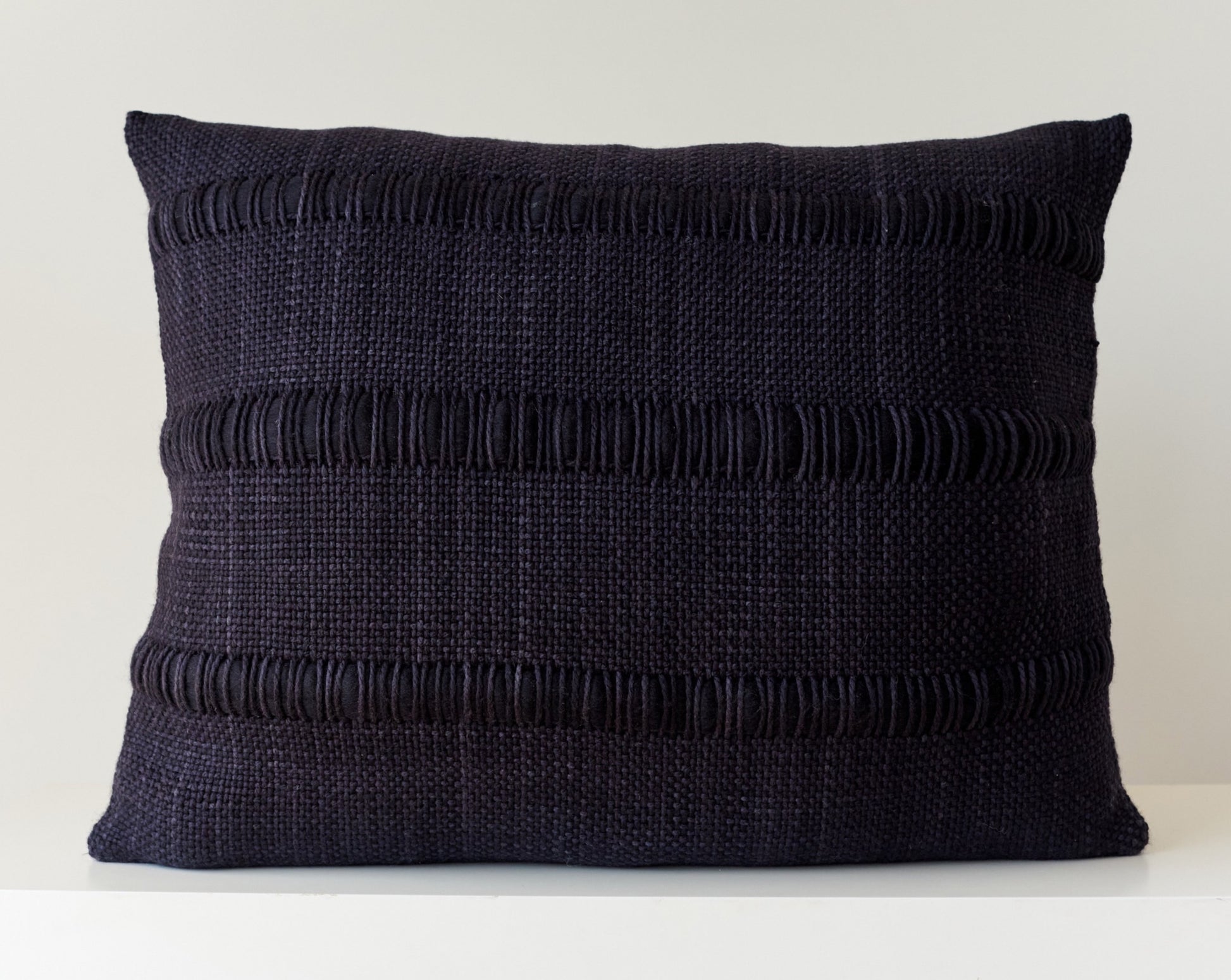 Black woven pillow handwoven with stripes of roving merino wool